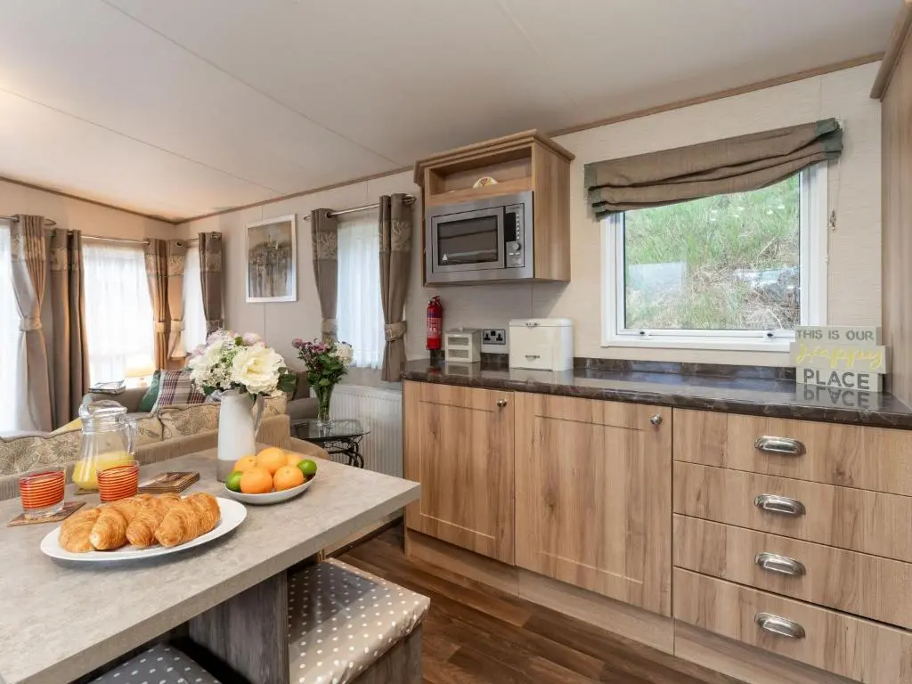 a kitchen with a table with a plate of food on it at Chalet Cairn View by Interhome in Aviemore