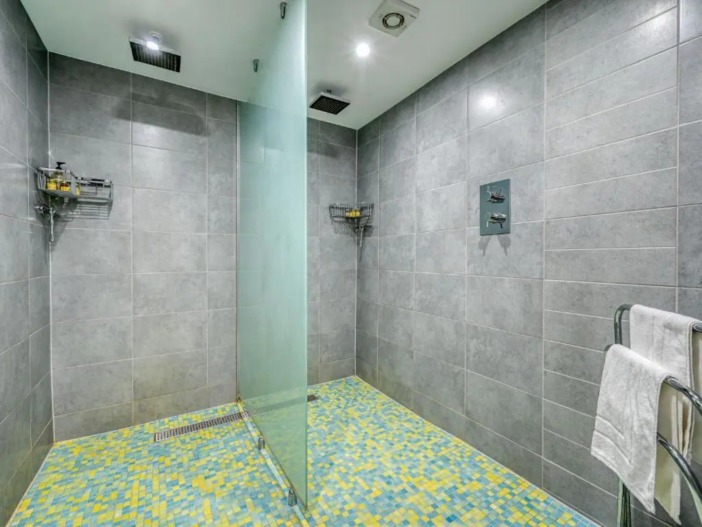 a bathroom with a shower with a glass door at Holiday Home Loch Ness Granary by Interhome in Invermoriston