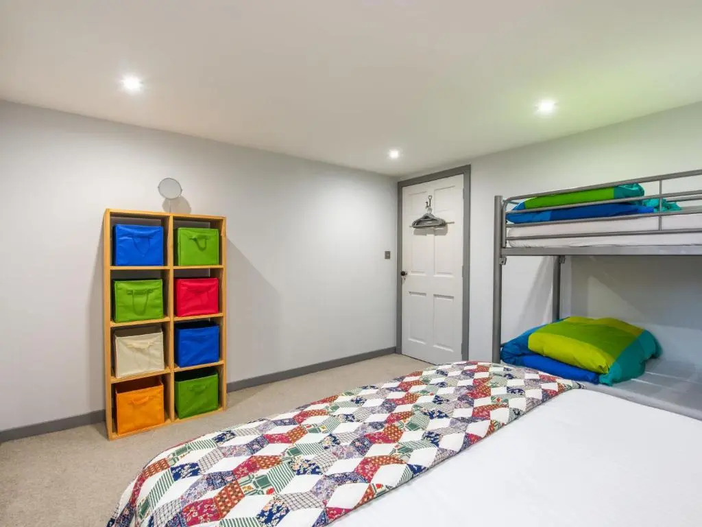 a bedroom with a bed and a bunk bed with colorful drawers at Holiday Home Loch Ness Granary by Interhome in Invermoriston