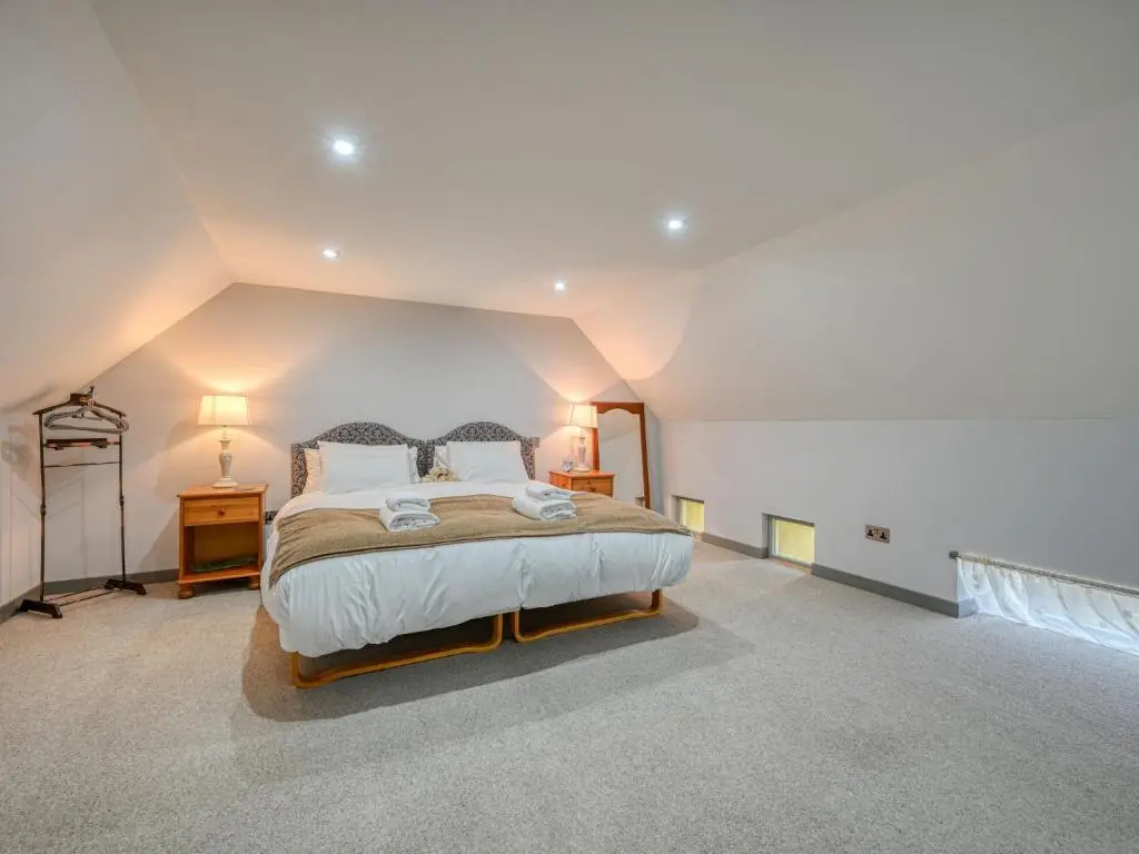 a bedroom with a large bed and a window at Holiday Home Loch Ness Granary by Interhome in Invermoriston