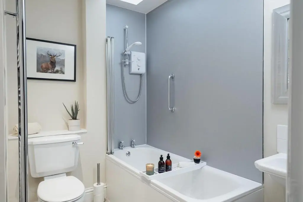 a bathroom with a shower and a toilet and a sink at The Old Smithy - Seasgair Lodges in Nethy Bridge