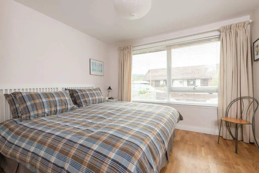 a bedroom with a bed and a large window at 4guests-2br-privategarden-freeparking in Aviemore