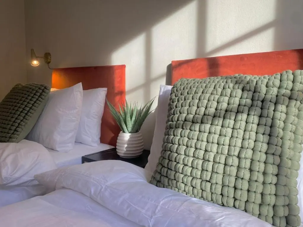 two beds with white comforters and a vase on a table at Warm, stylish 2-bed in Crown, Inverness in Inverness