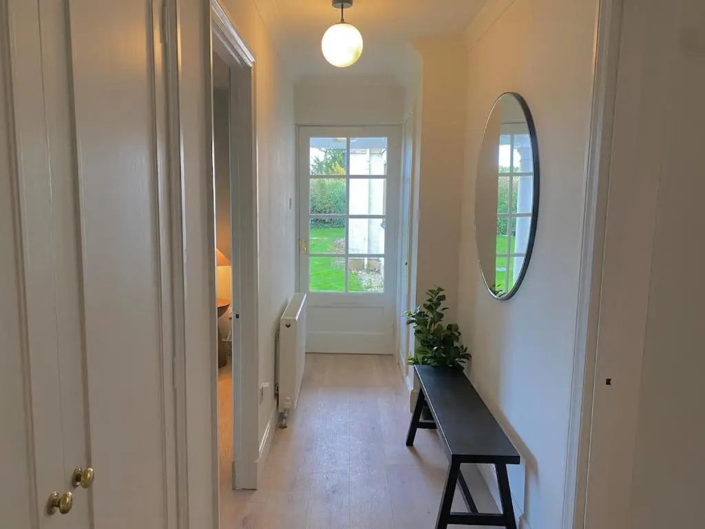 a hallway with a table and a mirror and a window at Warm, stylish 2-bed in Crown, Inverness in Inverness