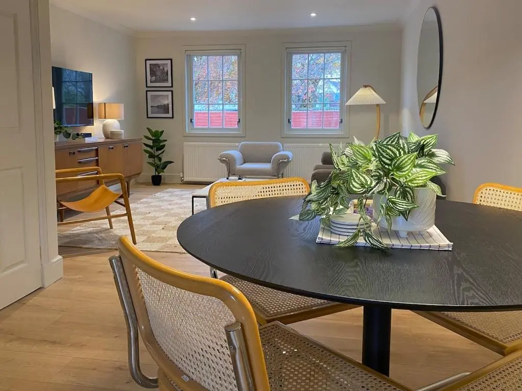 a dining room with a table with chairs and a mirror at Warm, stylish 2-bed in Crown, Inverness in Inverness