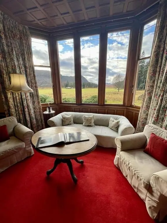 a living room with a couch and a table at Sherramore Lodge in Laggan