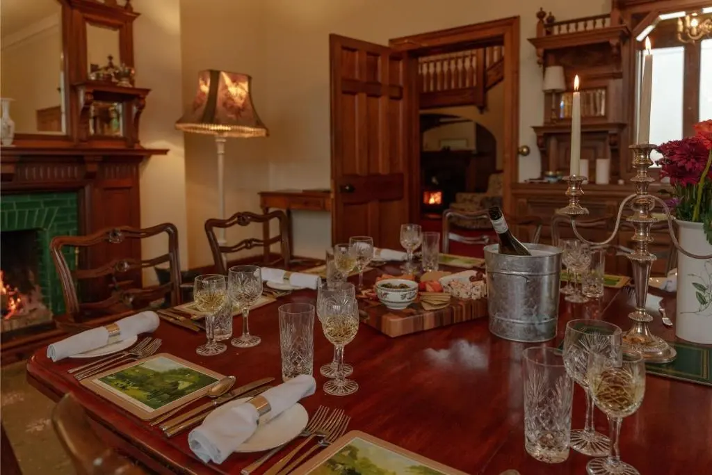 a dining room with a wooden table with wine glasses at Sherramore Lodge in Laggan