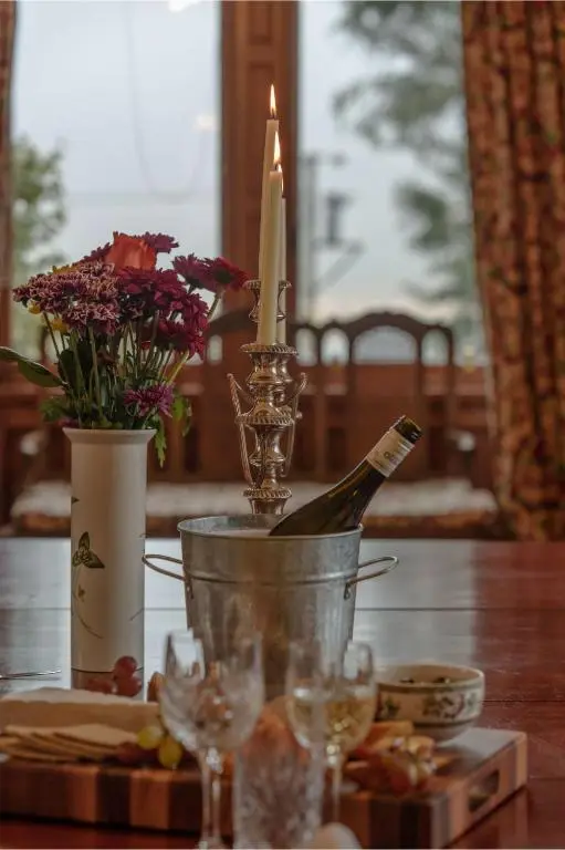 a table with a bottle of wine and a candle at Sherramore Lodge in Laggan