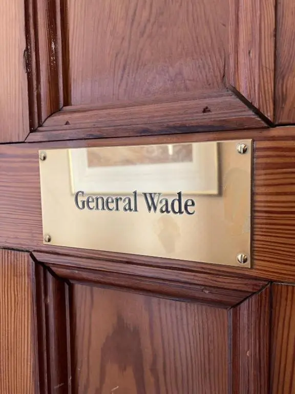 a sign on a wooden door that reads general wade at Sherramore Lodge in Laggan