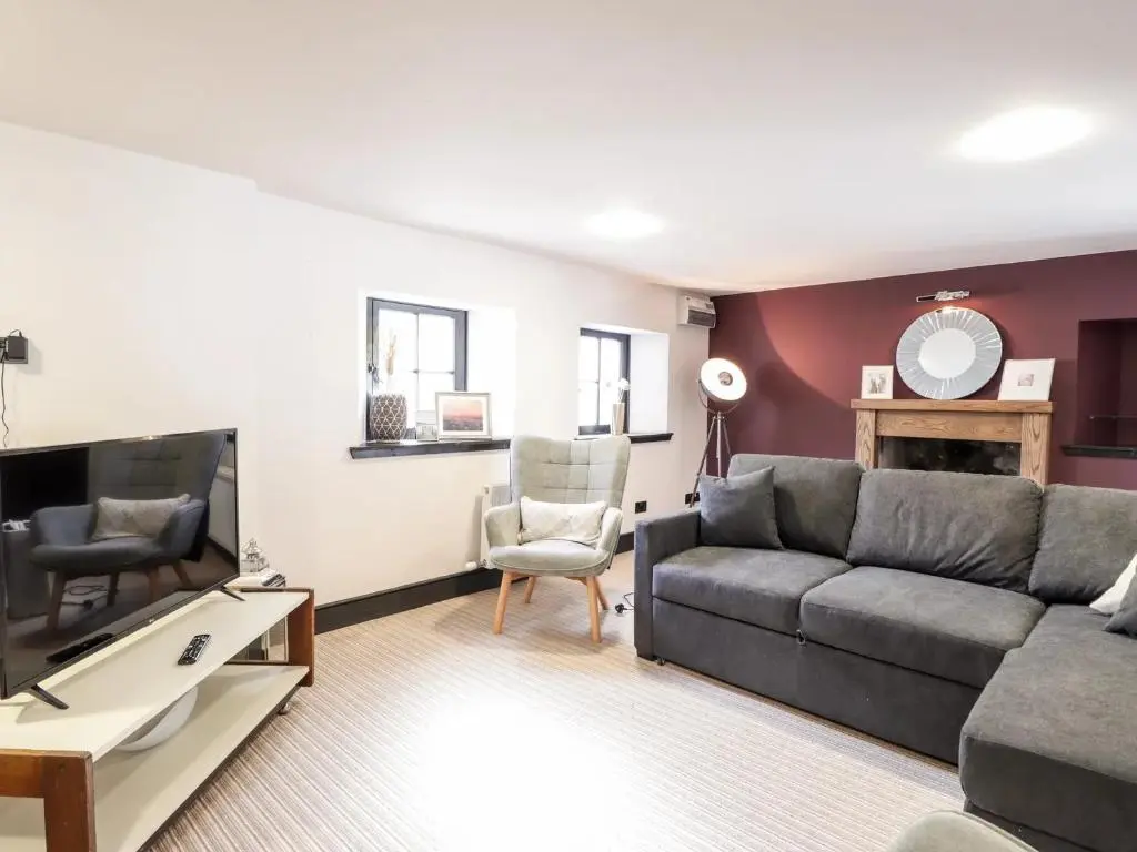 a living room with a couch and a tv at Mary Ann Apartment in Inverness
