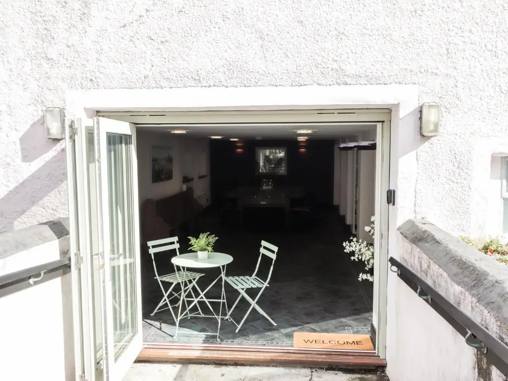 an open door to a patio with a table and chairs at Mary Ann Apartment in Inverness