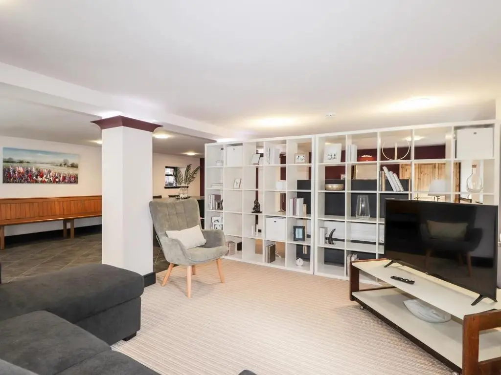 a living room with a couch and a television at Mary Ann Apartment in Inverness