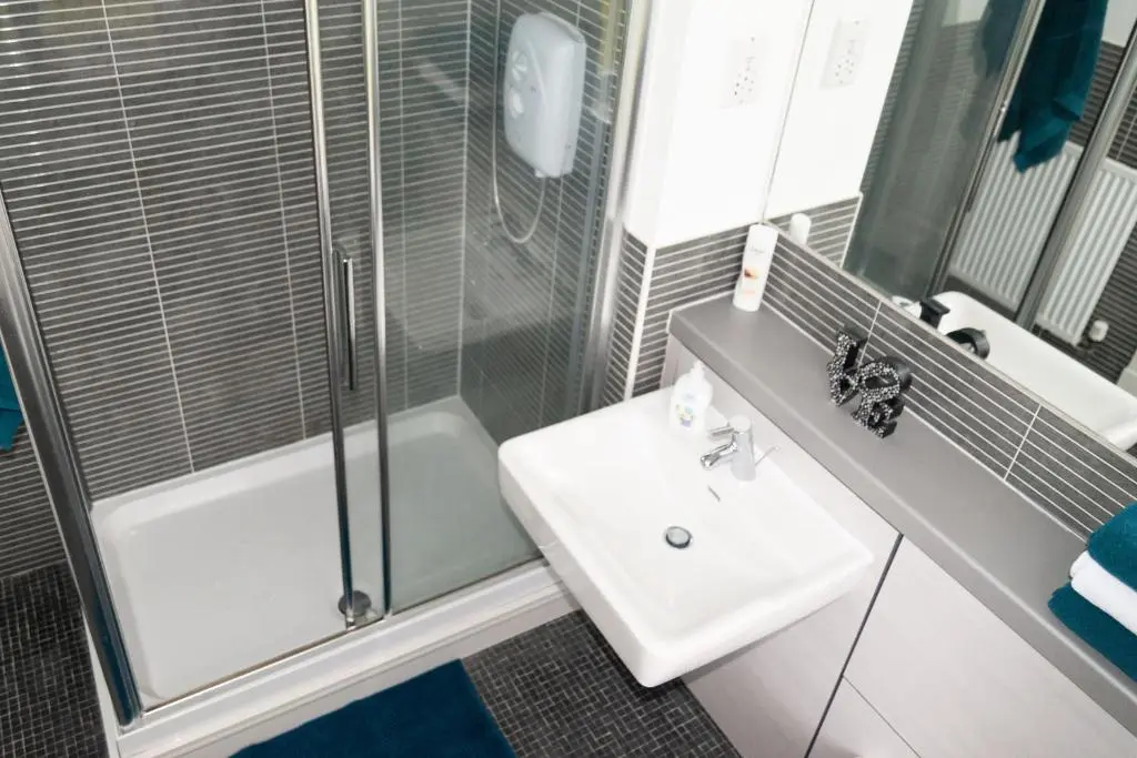 a bathroom with a glass shower and a sink at Junique Modern Ground Floor Apartment - 2 bedrooms in Aberdeen