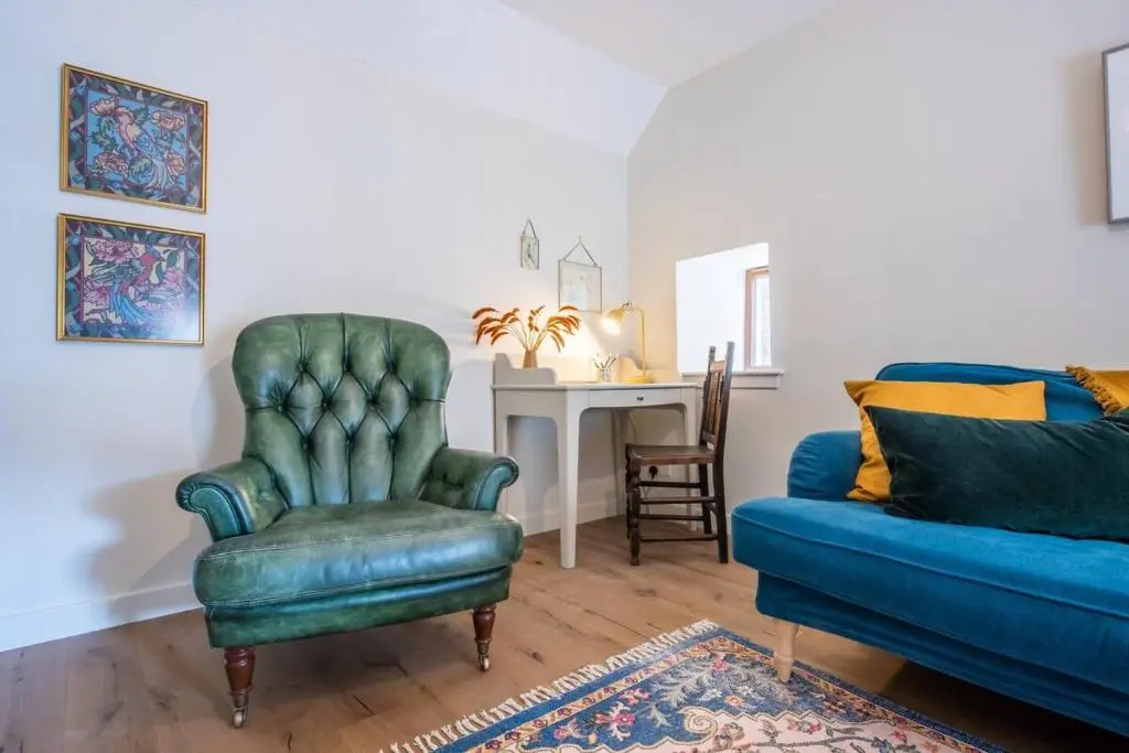 a living room with a blue chair and a couch at Weavers Cottage in Inverness