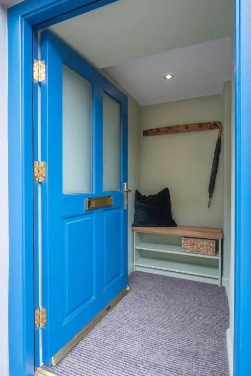 a blue door in a room with a bench at Weavers Cottage in Inverness