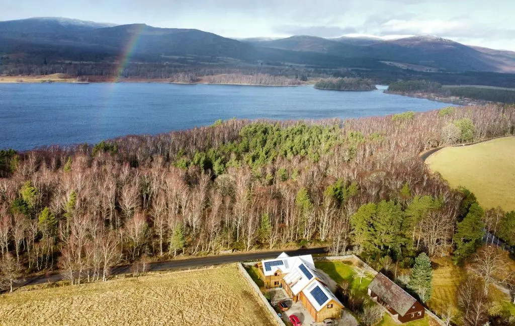 an aerial view of a lake and a rainbow at Telford Cottage in Kincraig