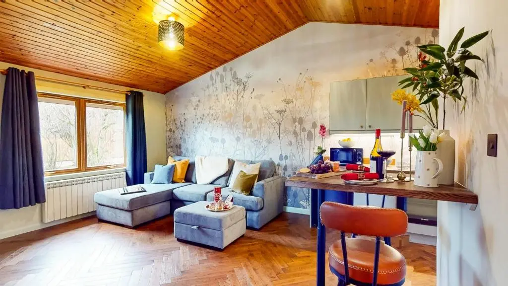 a living room with a couch and a table at Fraser Cottage in Kincraig