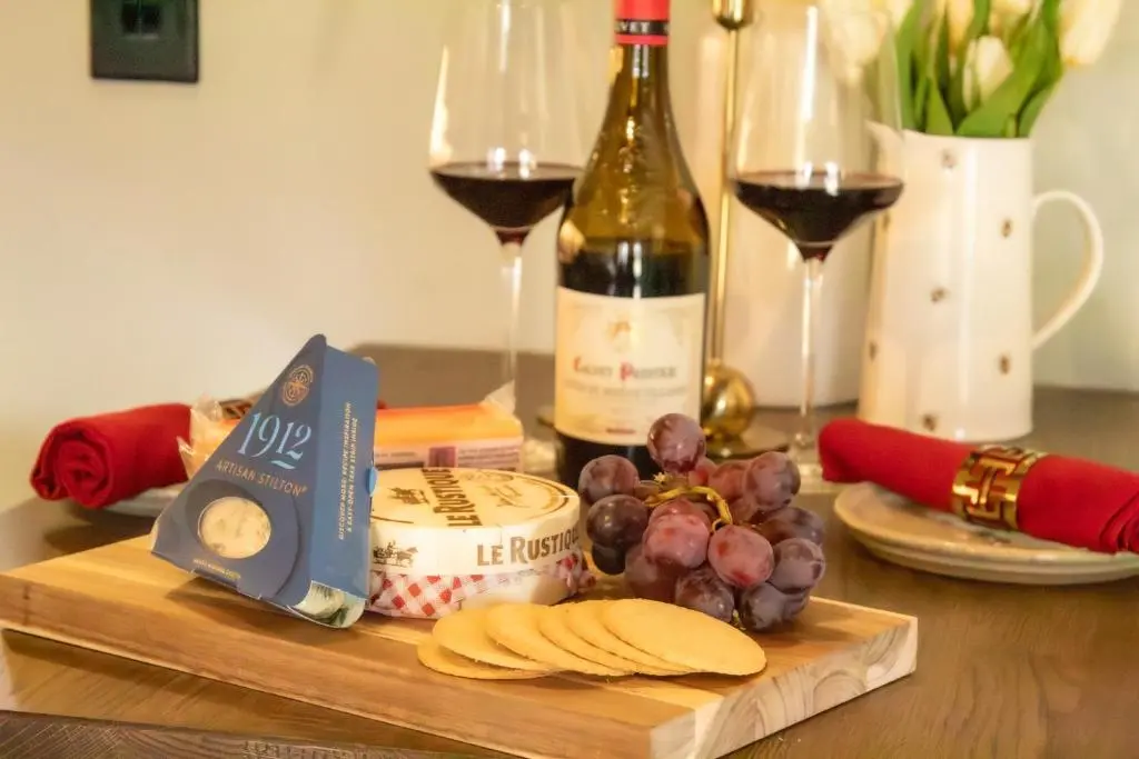 a table with a bottle of wine and some wine glasses at Fraser Cottage in Kincraig