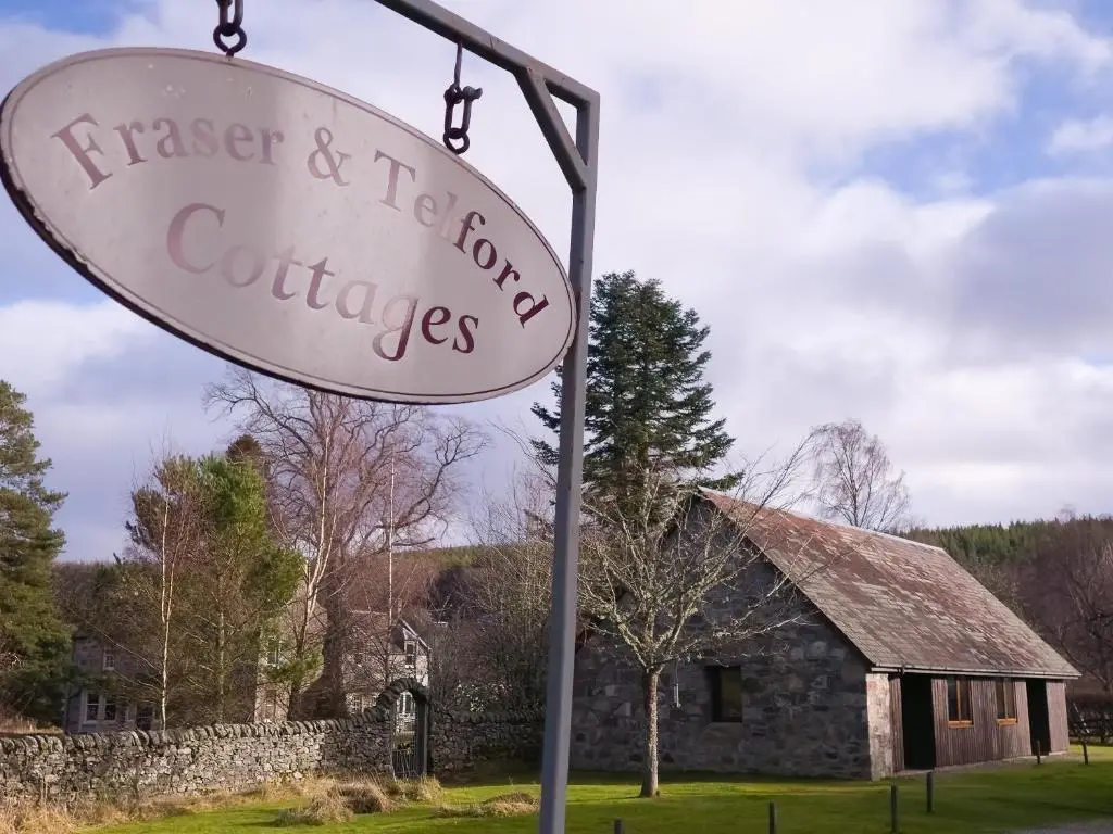 a sign in front of a stone building at Fraser Cottage in Kincraig