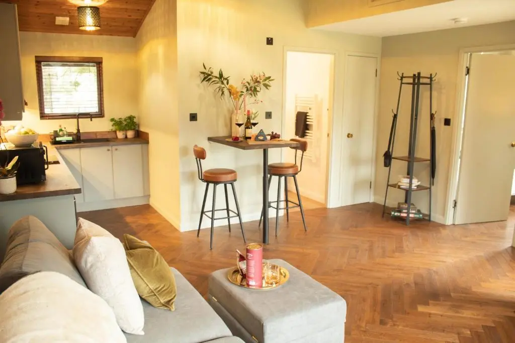 a living room with a couch and a kitchen at Fraser Cottage in Kincraig