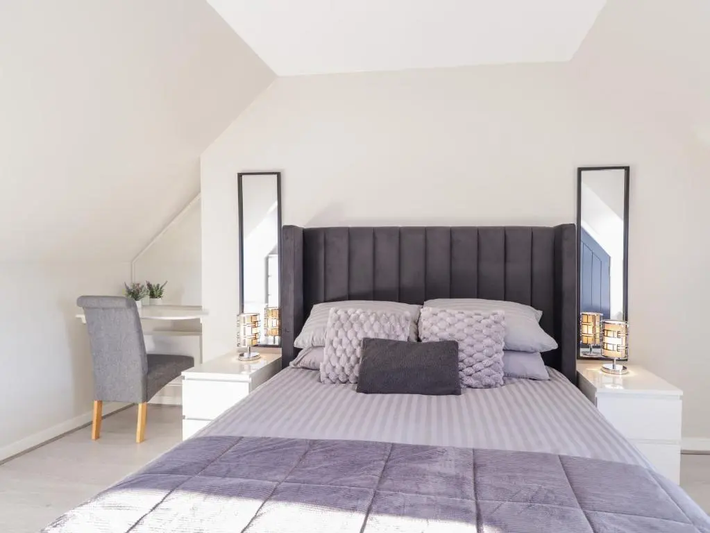 a bedroom with a large bed and a desk at 3 The Granary in Banff