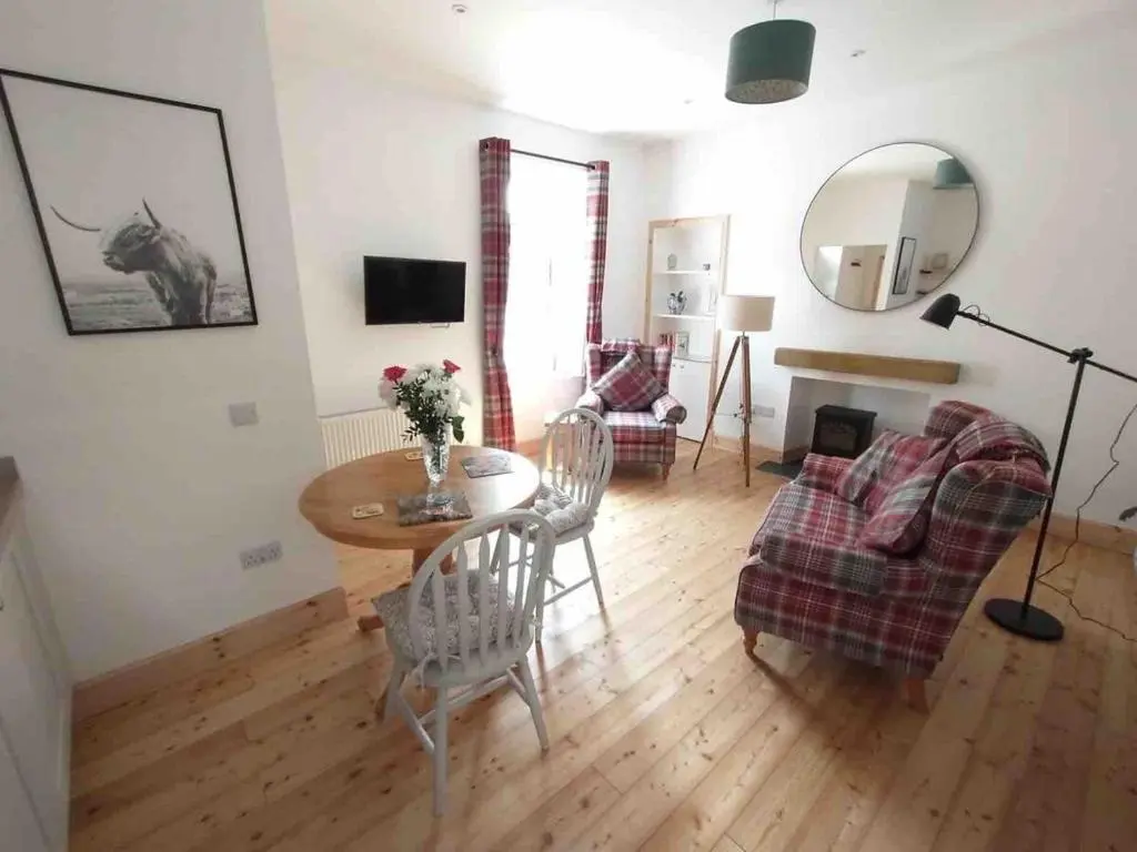 a living room with a table and a couch at River Retreat - Riverside Apartment in Inverness City Centre in Inverness