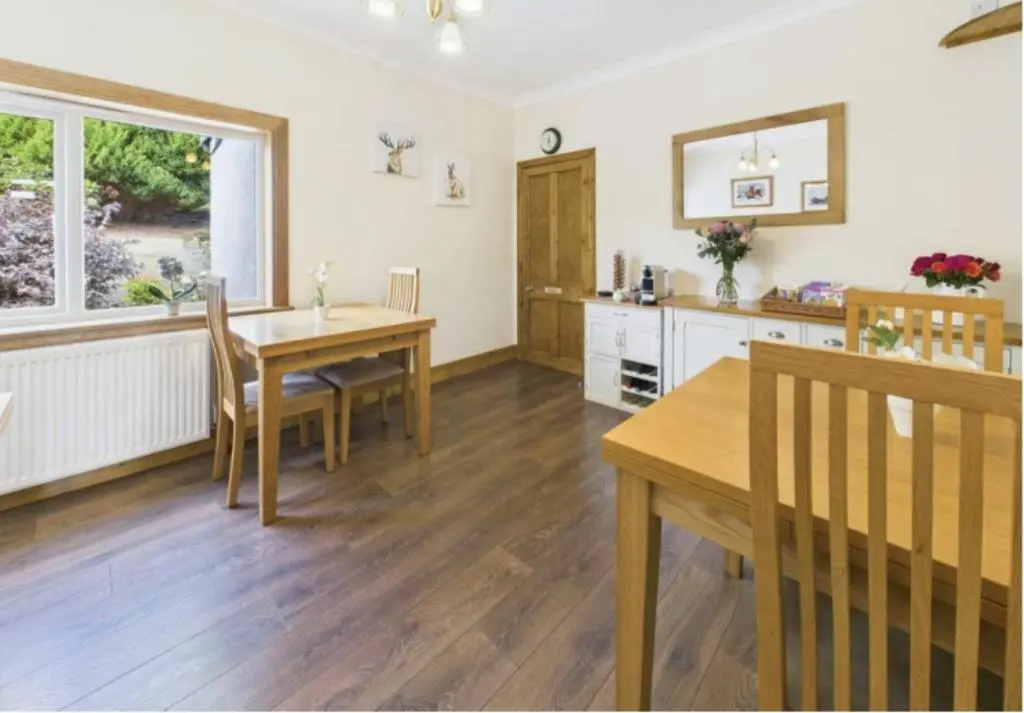a kitchen with a table and a dining room at Strathview Lodge B&B in Dornoch