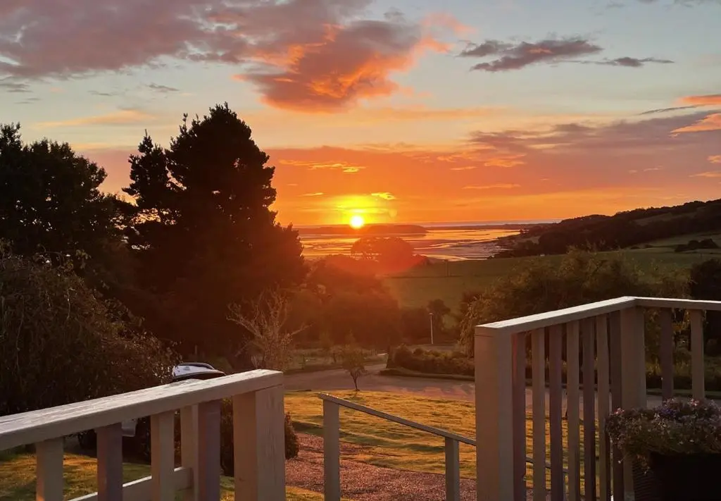 a sunset from a porch with the sun setting at Strathview Lodge B&B in Dornoch