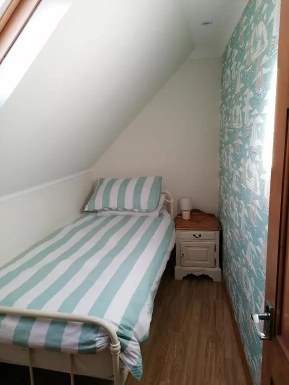 a small bedroom with a bed in a attic at Hytheview Cottage Whitehills in Whitehills