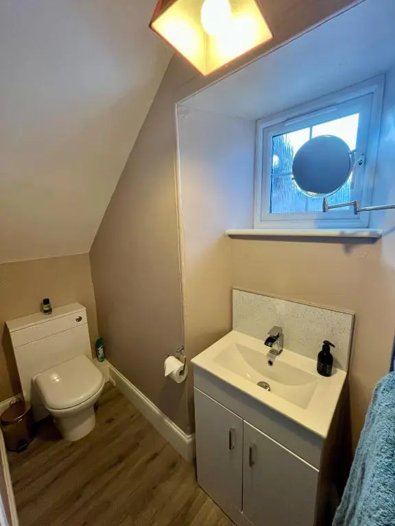 a bathroom with a sink and a toilet and a window at The Farmhouse Snug in Spean Bridge