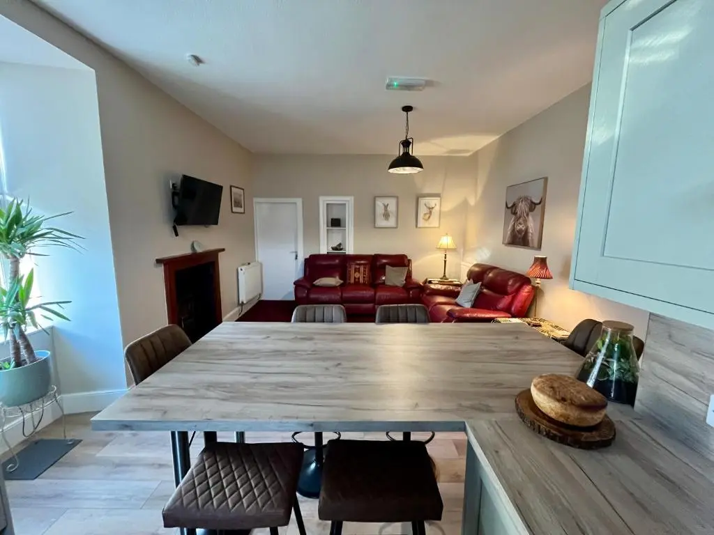 a living room with a large table and chairs at The Farmhouse Snug in Spean Bridge