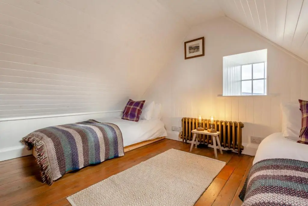 a attic room with two beds and a window at 2 Bed in Ardgay oc-w30780 in Achnahanat