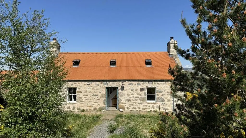 an old stone building with an orange roof at 2 Bed in Ardgay oc-w30780 in Achnahanat