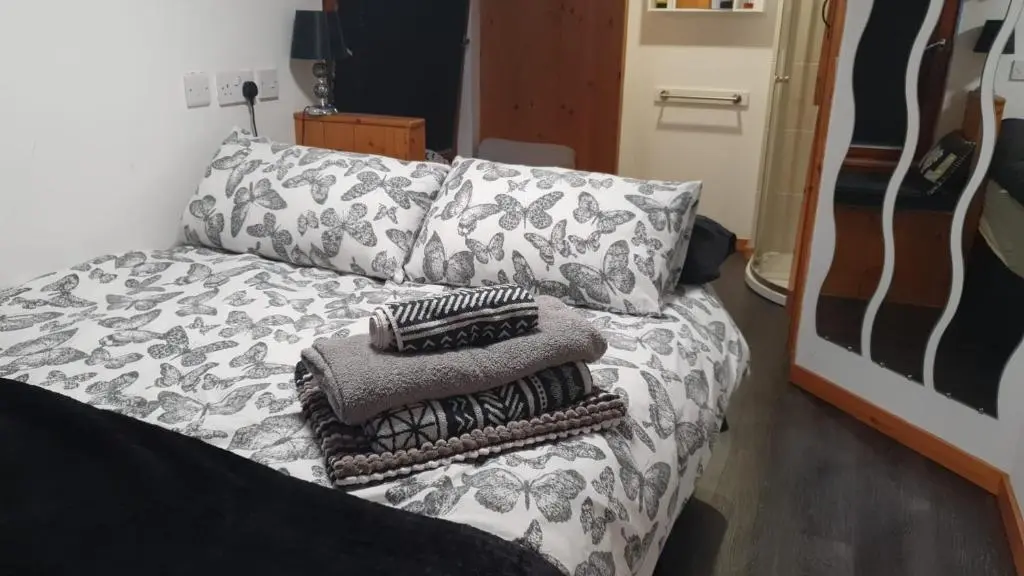 a bed with pillows on it in a room at Den of Allachlade in Aboyne