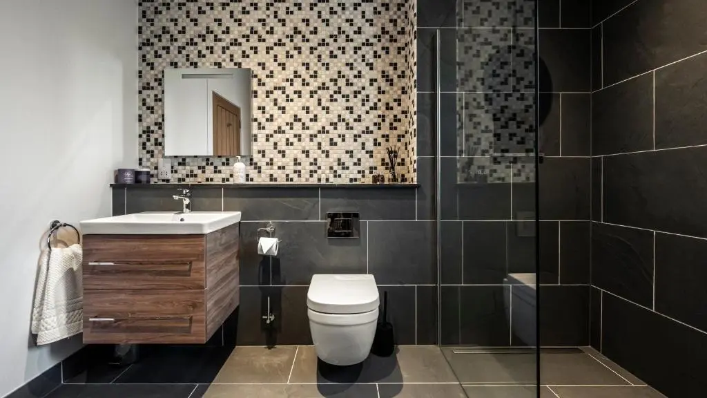 a bathroom with a toilet and a sink and a mirror at Holly Tree Cottage in Dornoch