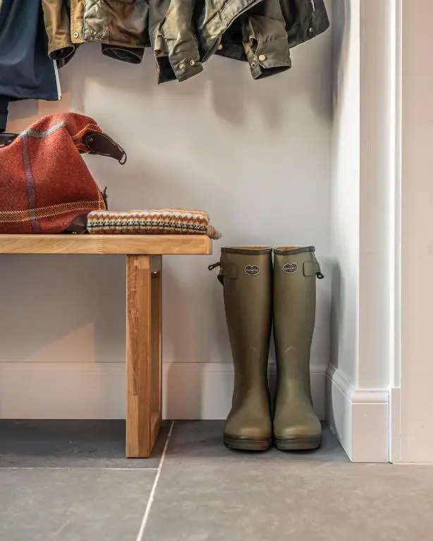 a pair of boots sitting next to a bench at Holly Tree Cottage in Dornoch