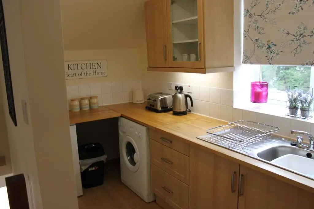 a kitchen with a sink and a washing machine at Druid Apartment in Inverness