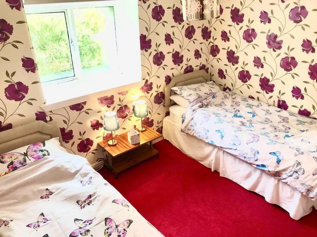 a bedroom with two beds and a window at Canal Side Cottage,on the banks of the Caledonian Canal in Inverness