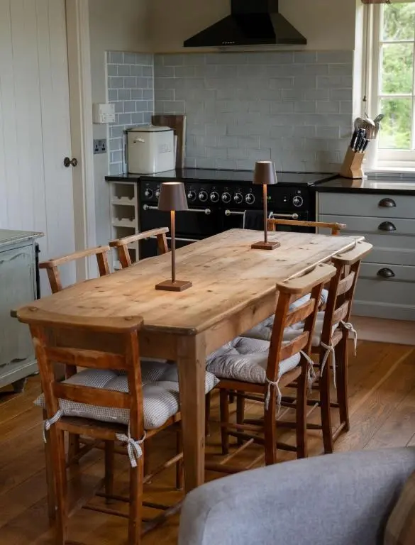a kitchen with a wooden table with chairs around it at Brachkashie Cottage, Loch Knockie in Whitebridge