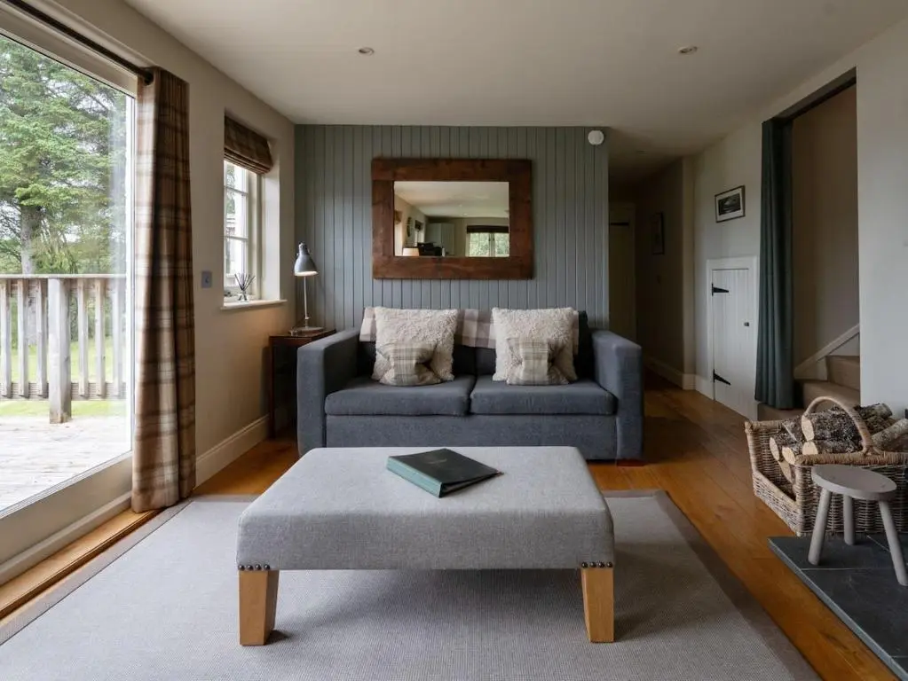a living room with a couch and a table at Brachkashie Cottage, Loch Knockie in Whitebridge