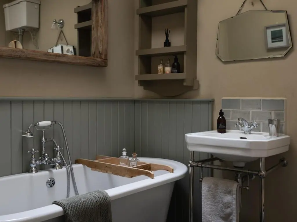 a bathroom with a tub and a sink and a bath tub at Brachkashie Cottage, Loch Knockie in Whitebridge