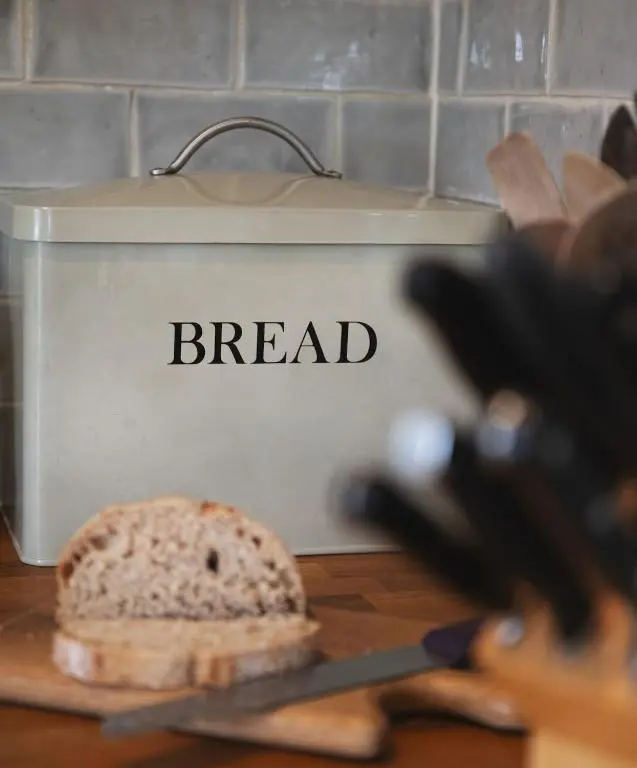 a loaf of bread on a cutting board next to a toaster at New Brachkashie Cottage in Whitebridge