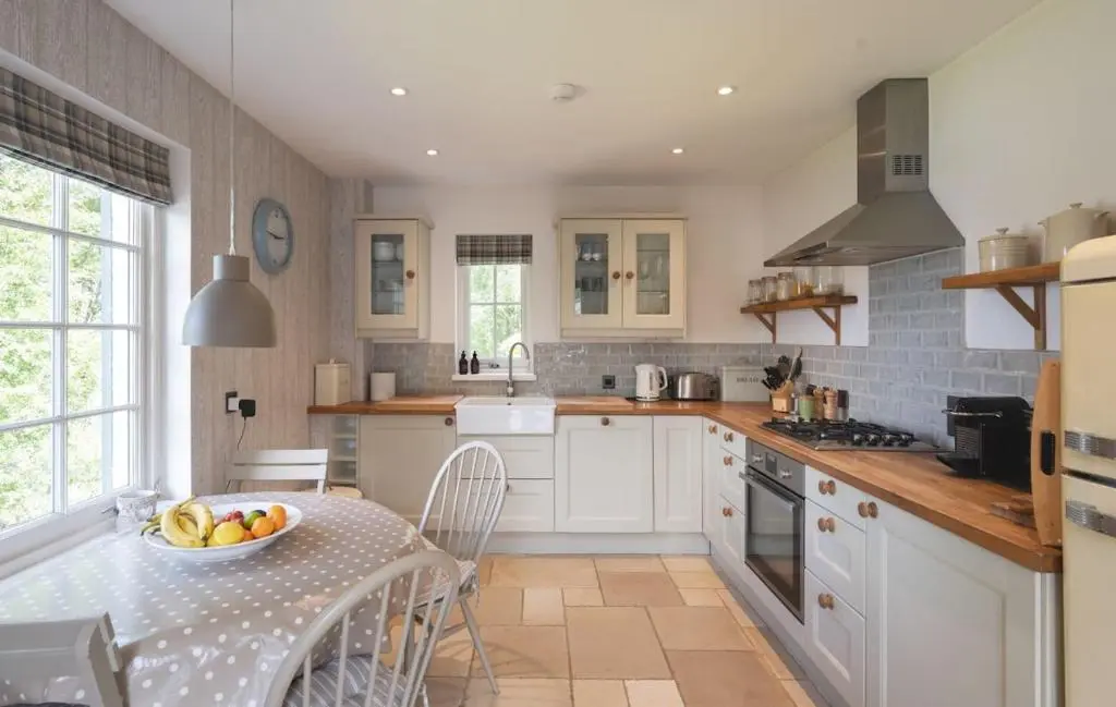 a kitchen with a table with a bowl of fruit on it at New Brachkashie Cottage in Whitebridge