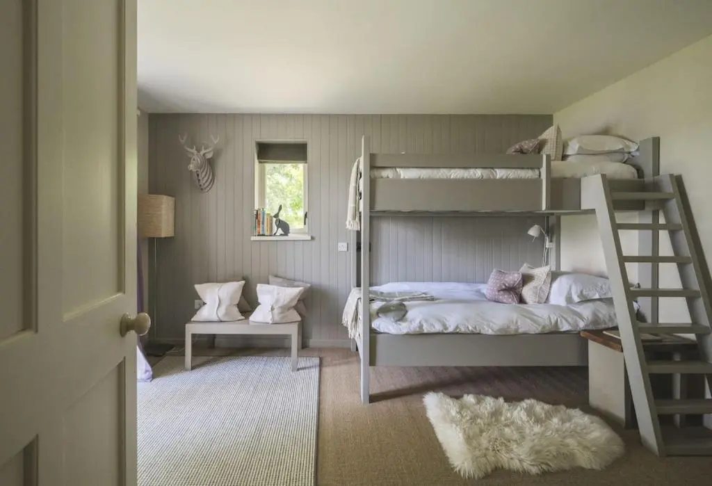a bedroom with two bunk beds and a ladder at New Brachkashie Cottage in Whitebridge