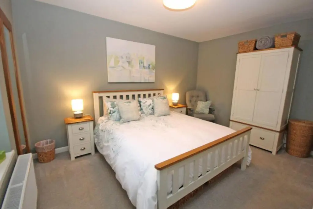 a bedroom with a bed with two night stands and two lamps at Findochty Beach house - Private Garden-BeachFront in Buckie