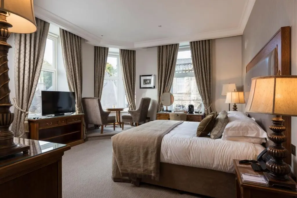 a hotel room with a bed and a television at The Station Hotel in Rothes