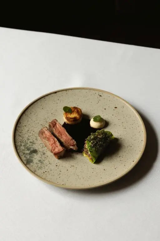 a plate with meat and vegetables on a table at The Station Hotel in Rothes