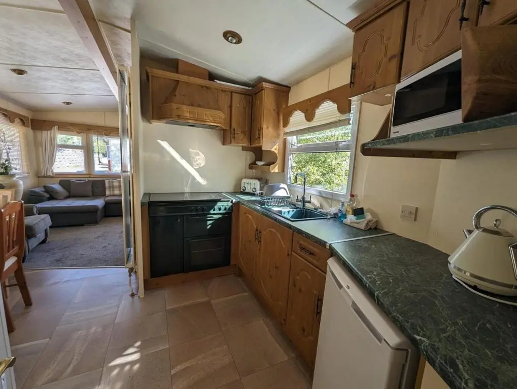 a kitchen with wooden cabinets and a green counter top at Highland getaway in kingussie golf club in Kingussie