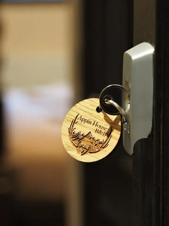 a wooden door knob with a sign that says i open hearts at Appin House B&B in Fort Augustus
