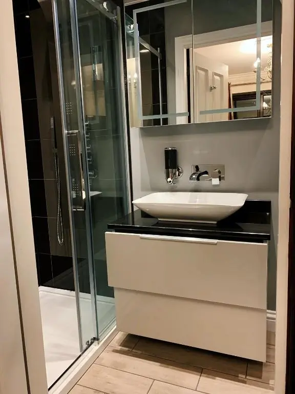 a bathroom with a sink and a glass shower at Appin House B&B in Fort Augustus